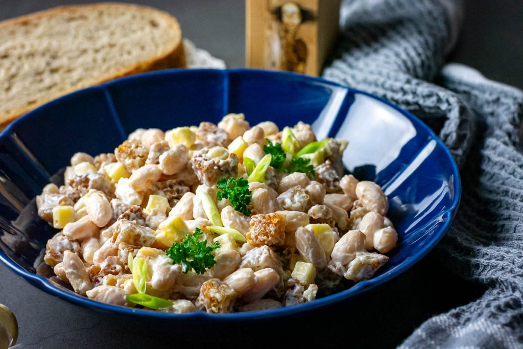 Lithuanian Bean Salad With Fried Bread in a blue bowl. 