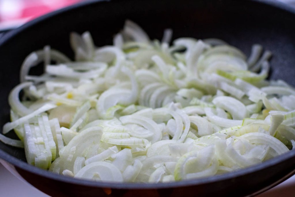 Sliced onion in a frying pan.