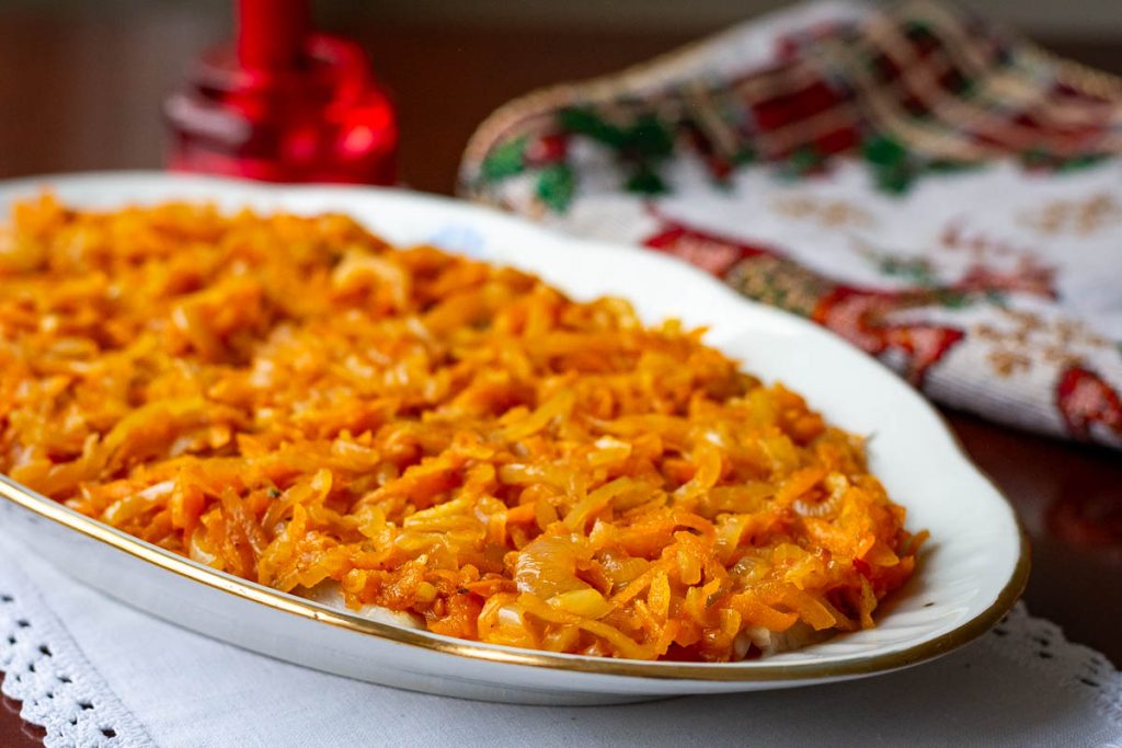 Sauteed onions and carrots spread over the herring.