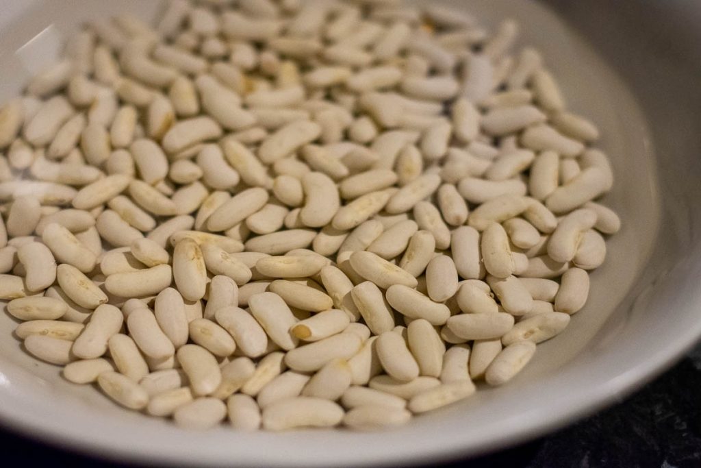 Beans placed in a bowl with cold water the night before making bean soup. 