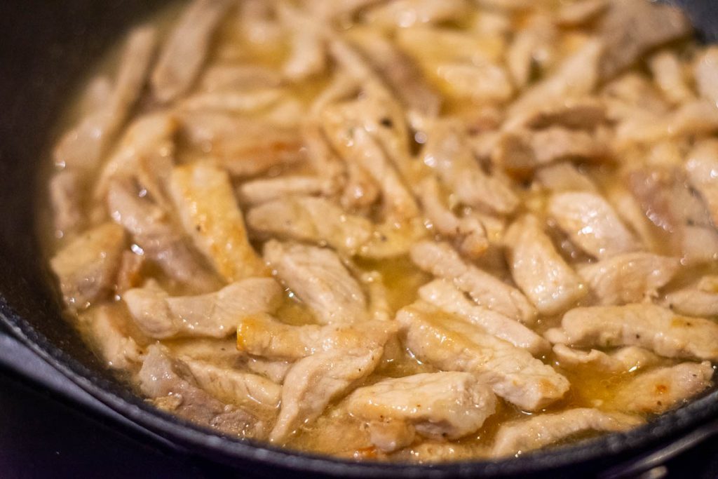 Simmering pork in stock.