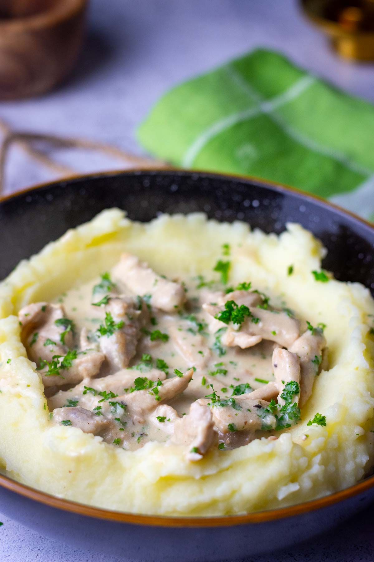 Creamy Lithuanian pork in sour cream sauce on a bed of mashed potatoes.