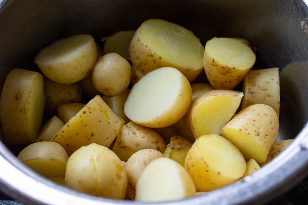 Boiled baby potatoes in a pan.