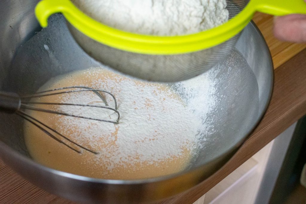 Sifting the flour into the wet ingredients.