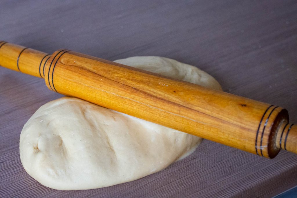 Beating the anthill dough with a wooden rolling pin.