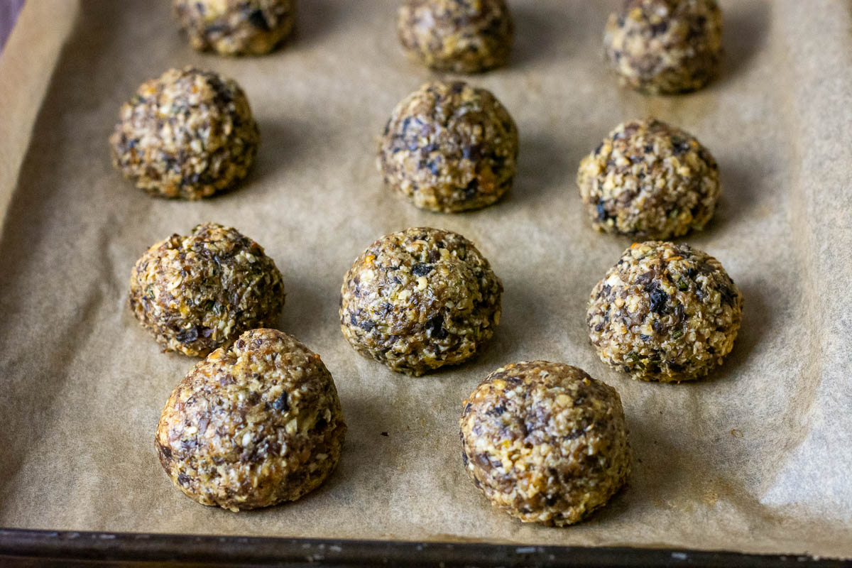 Baked mushroom balls on a baking sheet lined with parchment paper. 