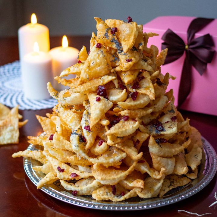 Lithuanian anthill stacked tall on a large platter with honey drizzle, poppy seeds and decorated with dried cranberries.