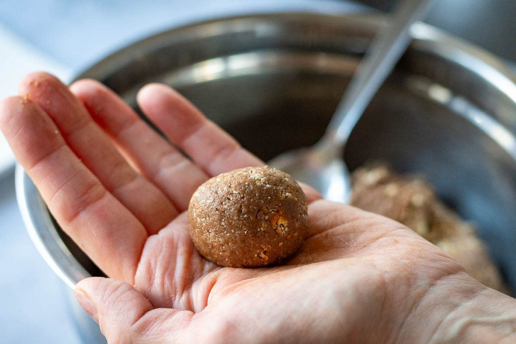 A ball of coco and condensed milk mixture shaped on a palm of a hand.
