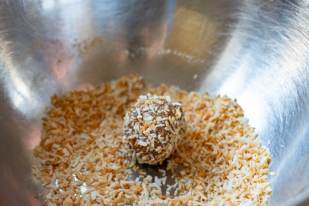 Lithuanian truffle being rolled in hazelnuts.