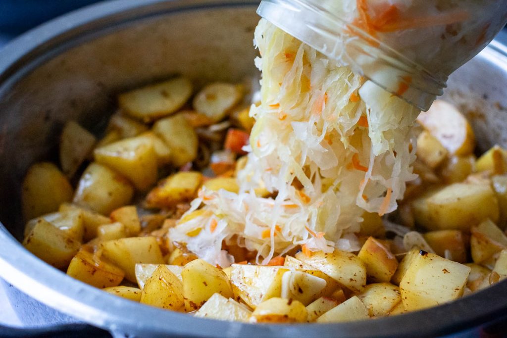Tipping the sauerkraut into the pan.