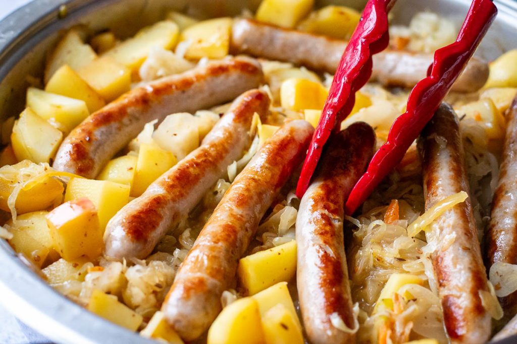 Nestling the sausages in the sauerkraut mixture.