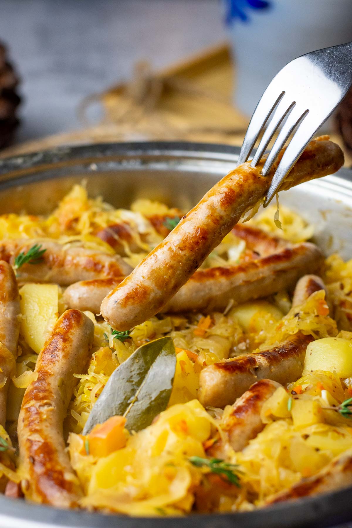 Cooked Lithuanain sauerkraut with sausages and potatoes on a dinner table.