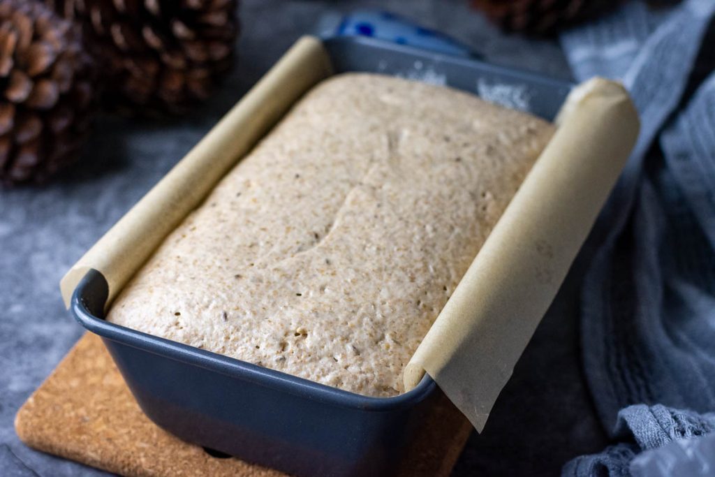 Lithuanian rye bread dough in a loaf pan after second proof.