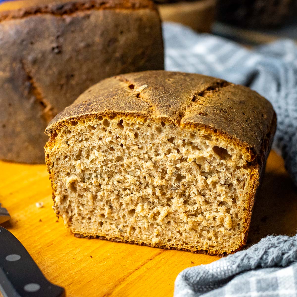 Cut Lithuanian Rye Bread with caraway seeds on a wooden board.
