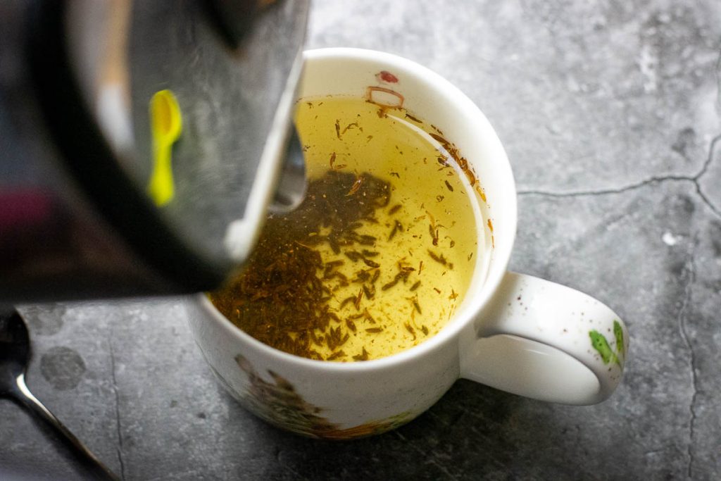 Pouring hot water over the caraway seeds. 