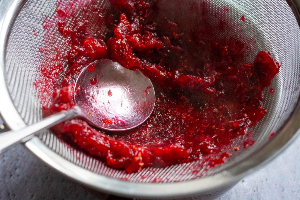 Straining the cranberries through a fine sieve.