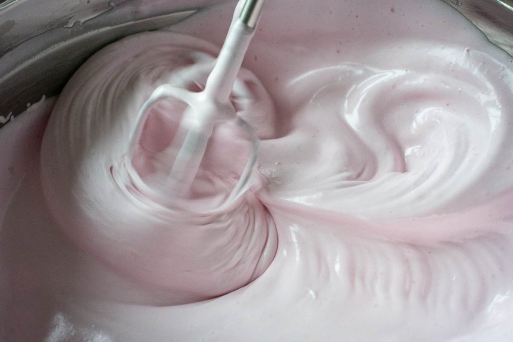 Whisking the pale pink egg whites fater adding sugar syrup.