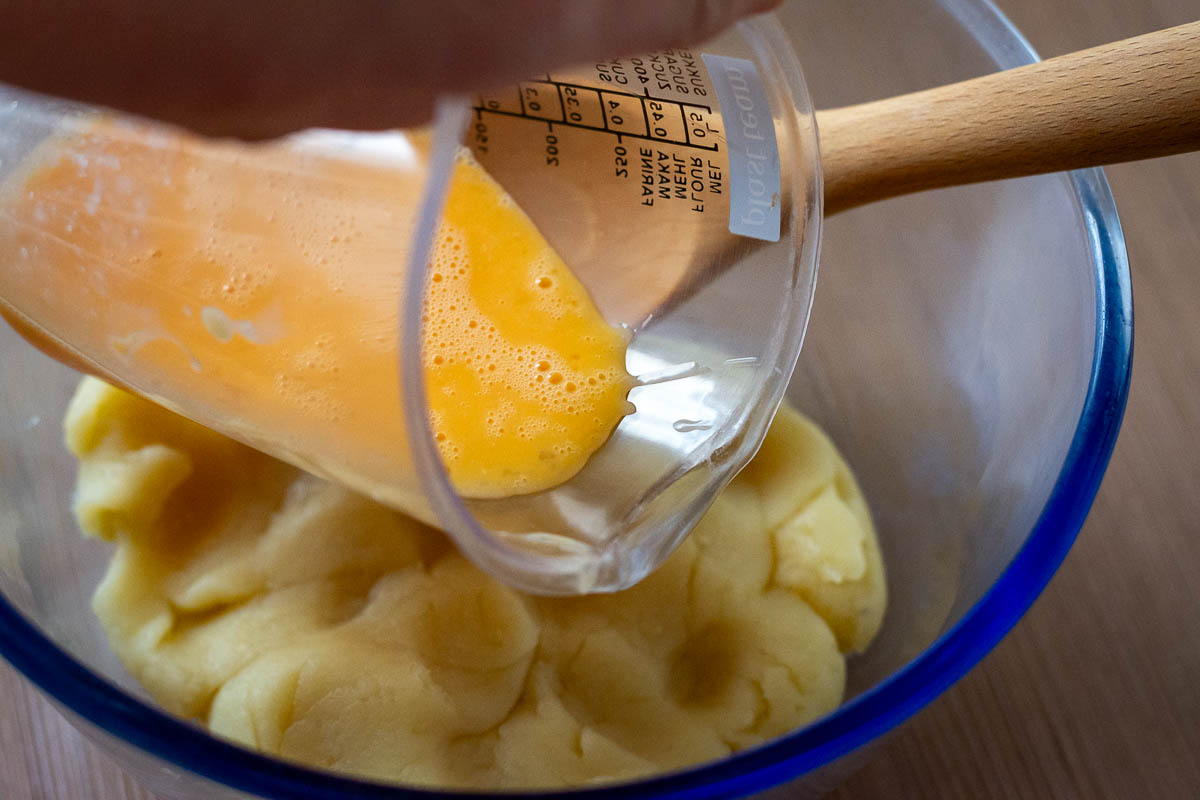 Adding the eggs to the flour mixture.
