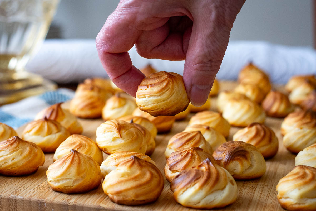 A hand picking up one of the Lithuanian cookies from a mound of them.