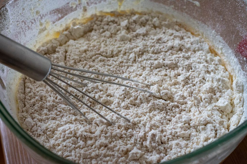 Stirring in dry ingredients into the honey egg mixture.