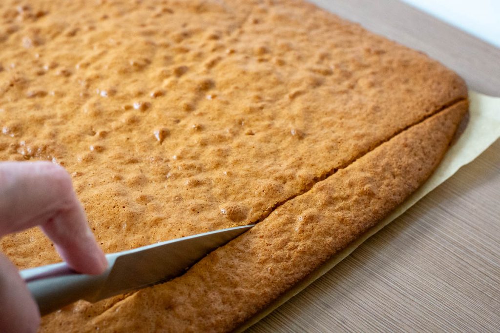 Trimming the edges of Lithuanian Honey Sponge cake.