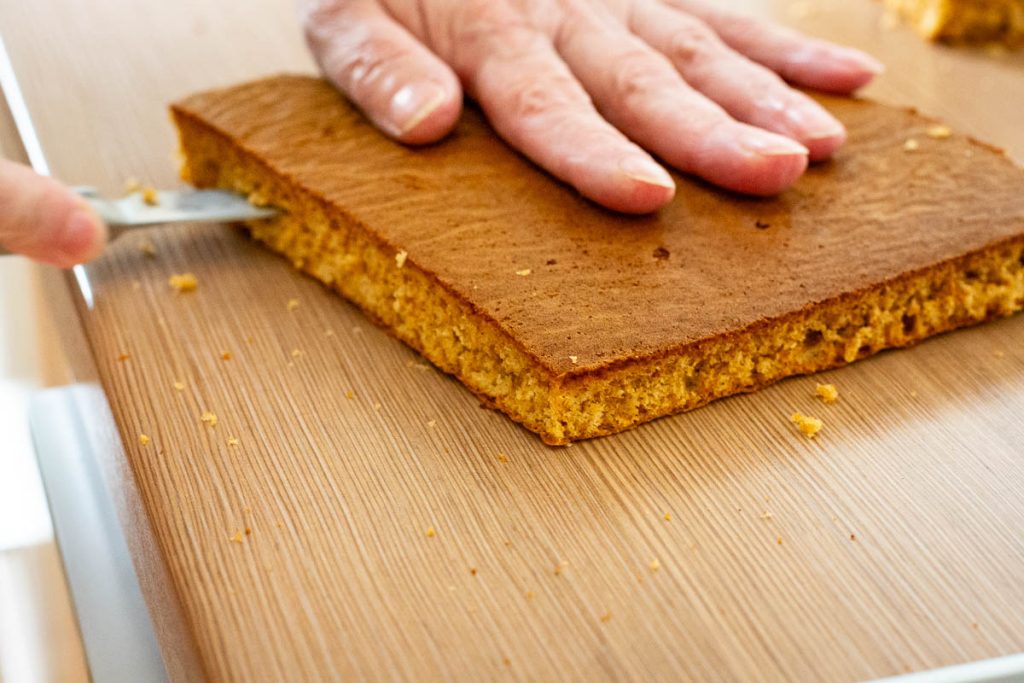 Cutting each sponge piece into two thin layers.
