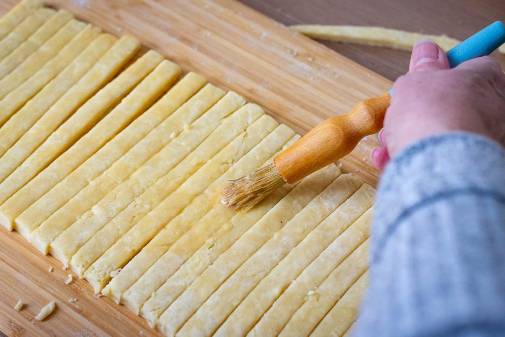 Brushing the Lithuanian cheese straws with egg wash. 