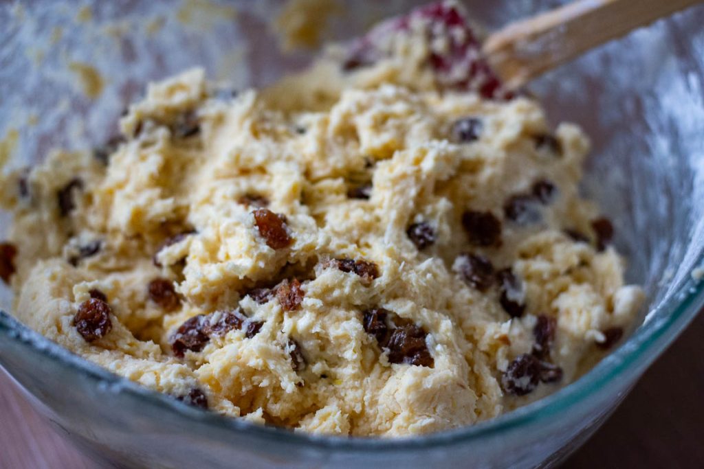 Stirring soaked raisins into the thick cake batter.