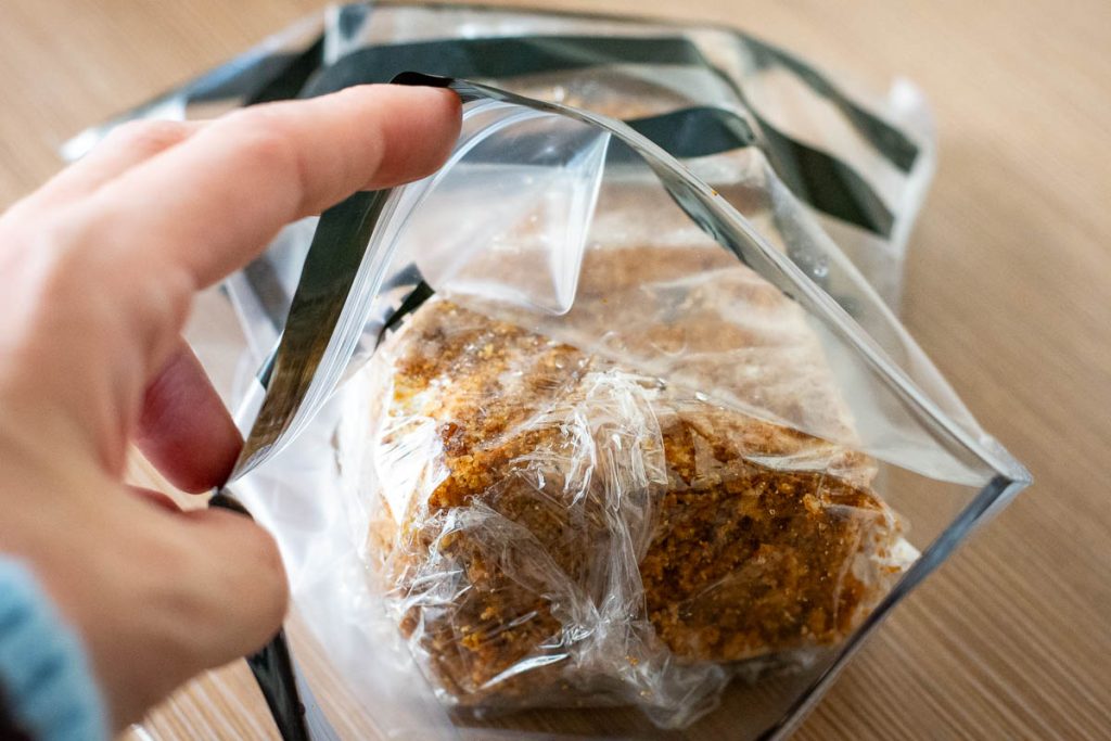 A large piece of Lithuanian Honey Cake wrapped in plastic wrap and placed in a ziplock bag.
