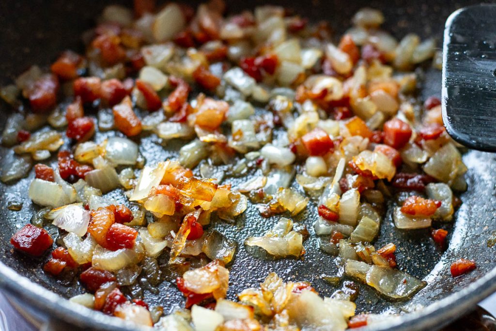 Onion and bacon in a pan. 