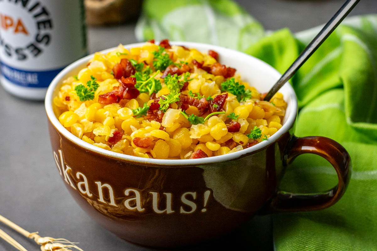 Lithuanian yellow split peas and bacon garnihsed with parsley in a brown bowl that has Skanaus (Bon Appetite!) wtritten across it!