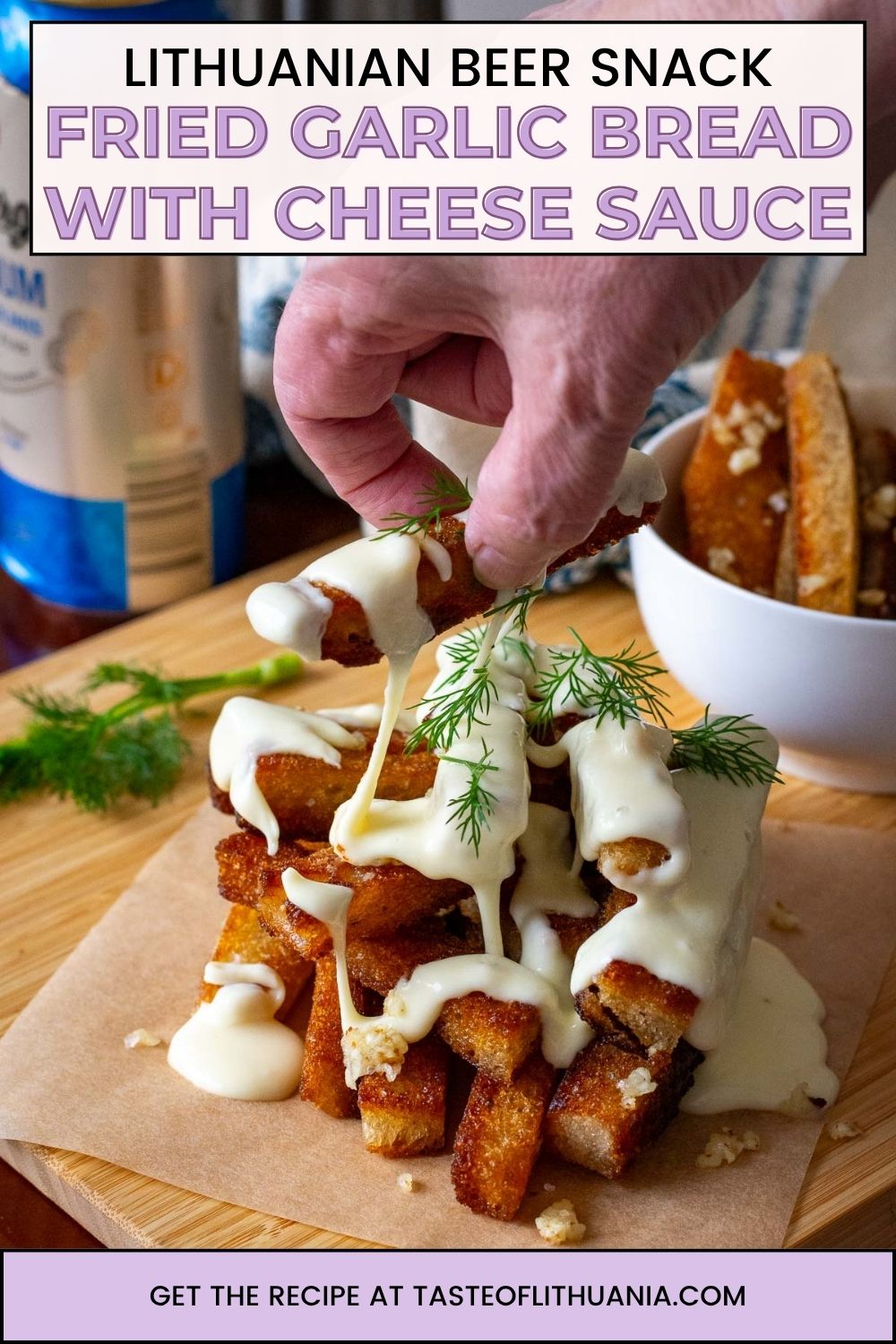 Lithuanian fried bread stacked and topped with cheese sauce on a wooden board. Pin for Pinterest. 
