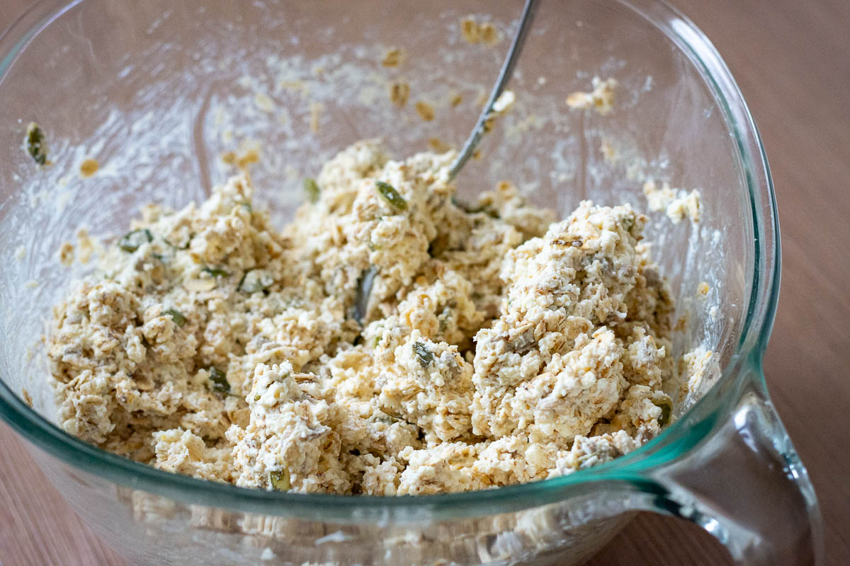 Thick farmer's cheese bread mixture in a glass mixing bowl.