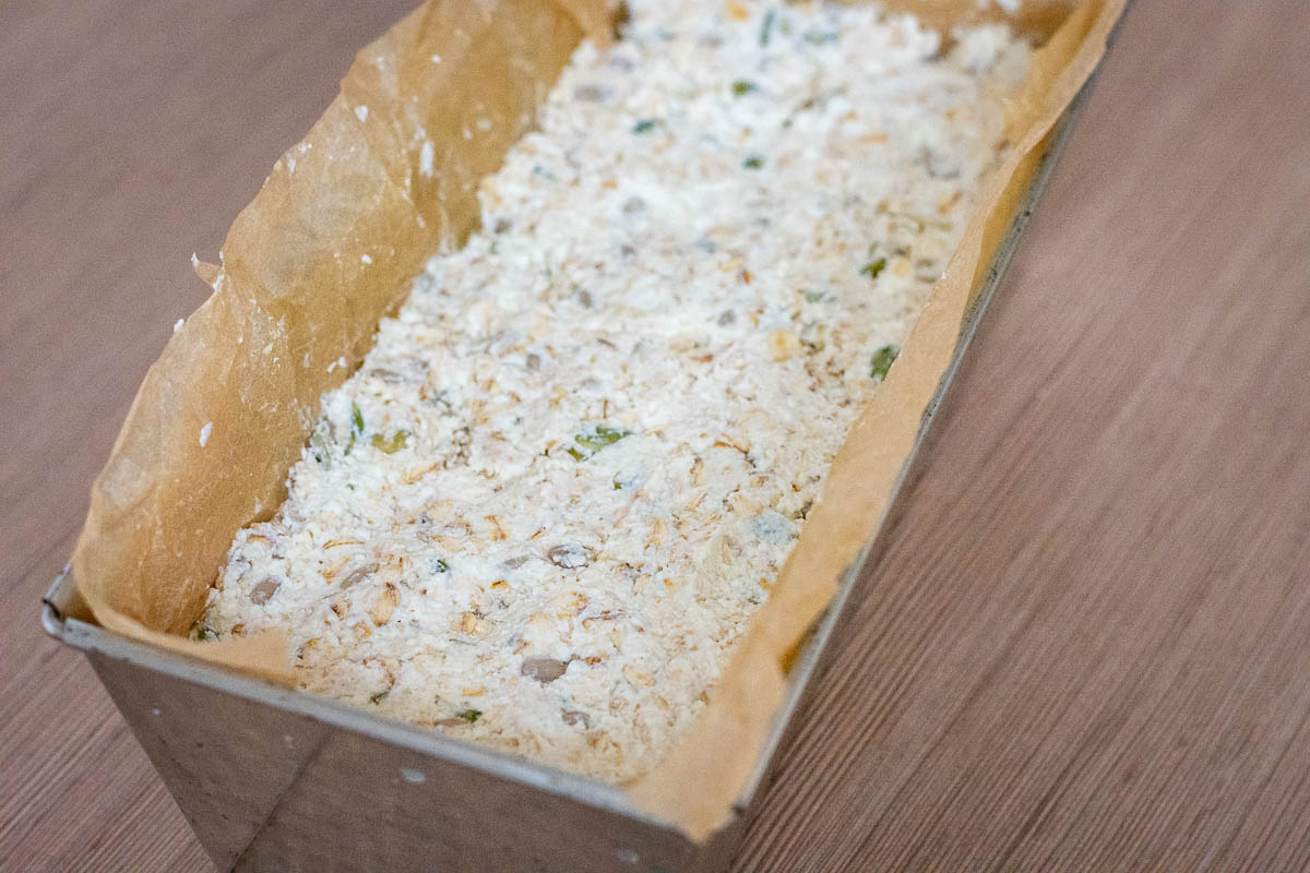 Dough transfered to a loaf pan lined with parchment paper.