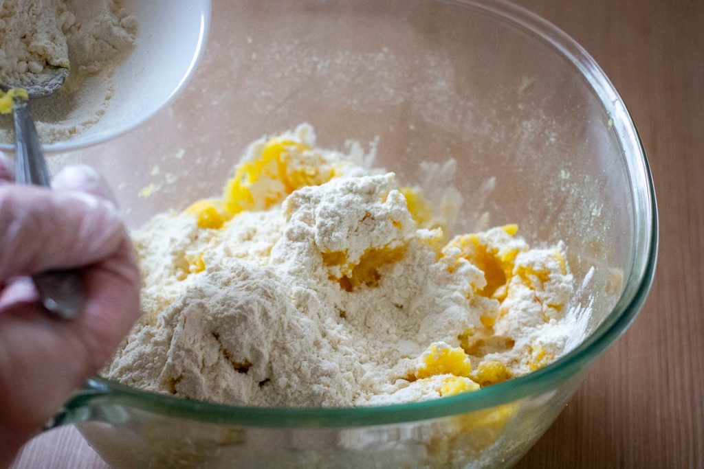 Mashed potato, seasoning and flour in a glass mixing bowl