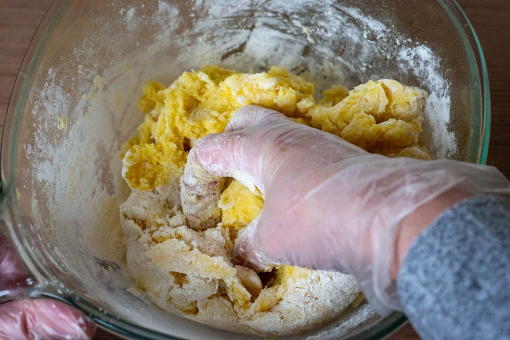 Bringing potato dough together with a hands.