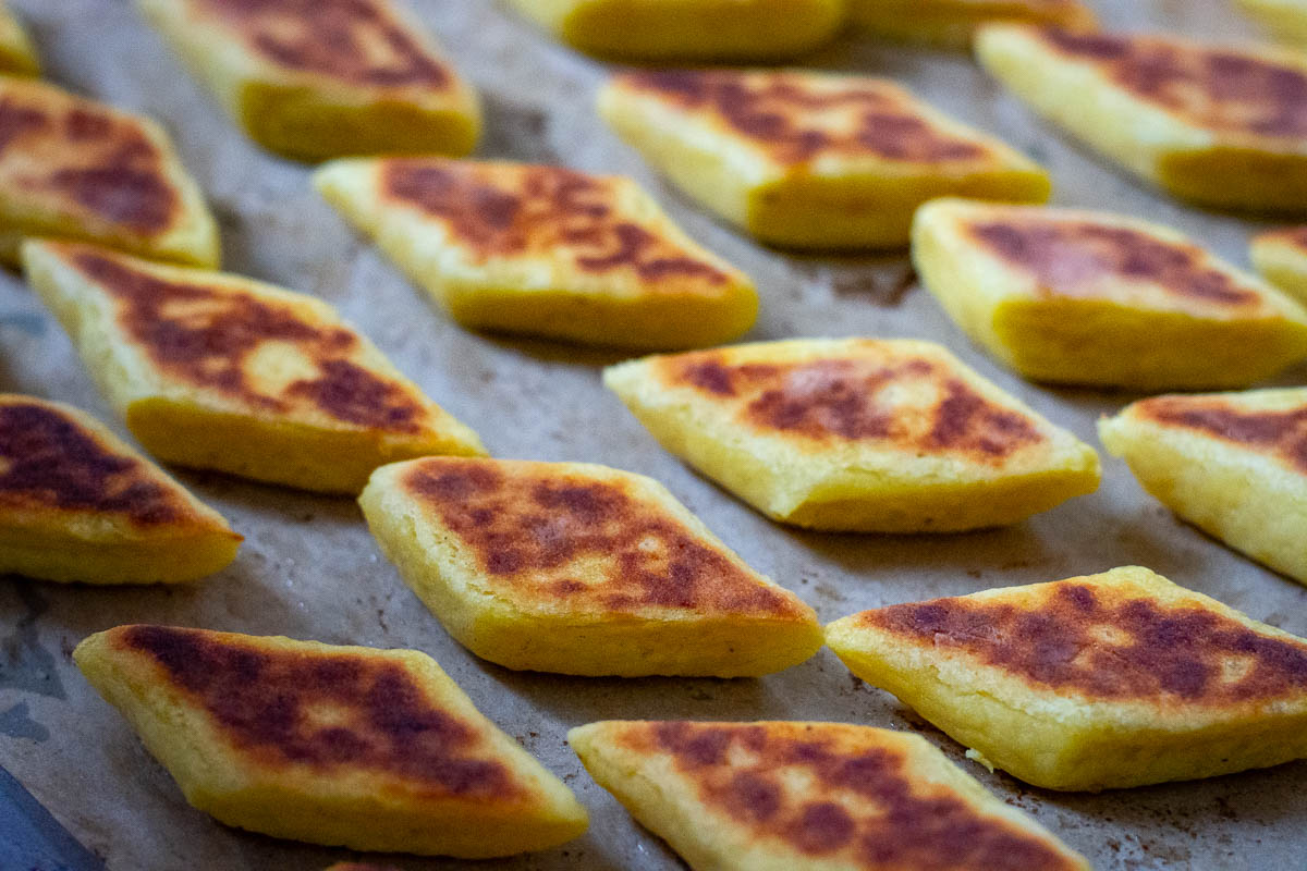 Baked svilpikai on a baking sheet lined with parchment paper.