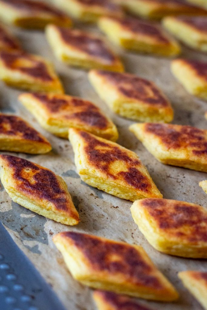 Golden browl baked mashed potato bites on a baking sheet.