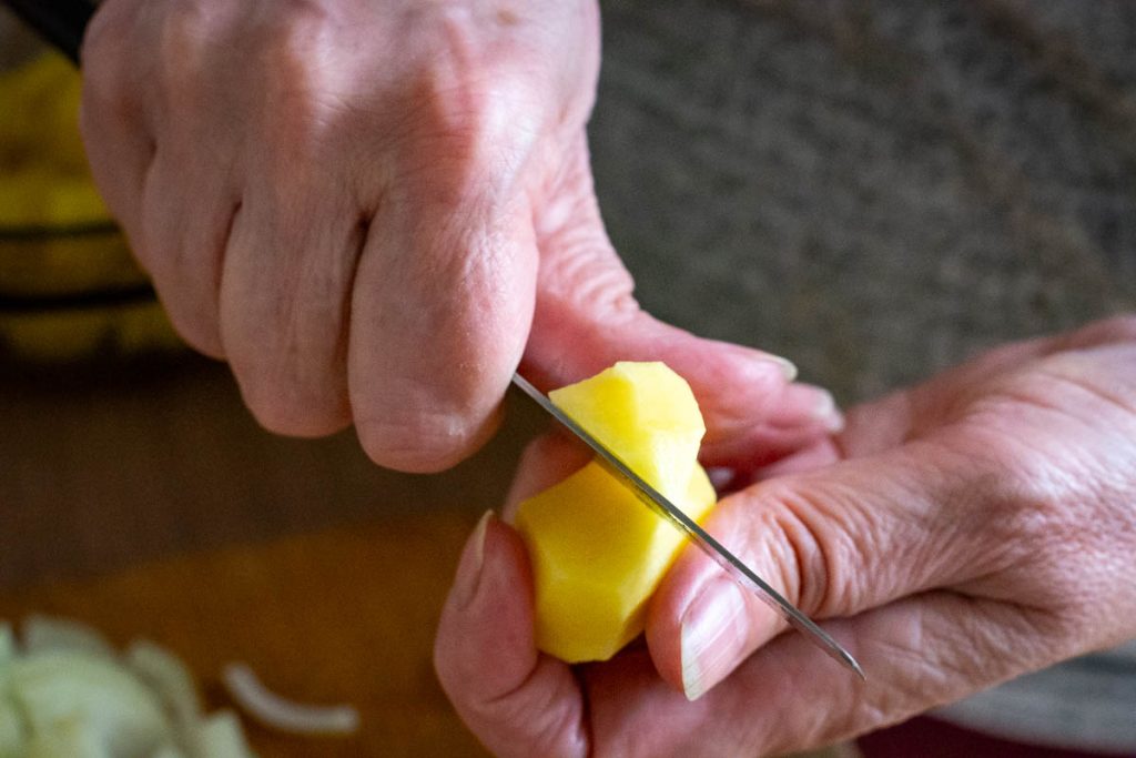 Cutting potatoes with a knife Lithuanian way that allows for uneven edges.