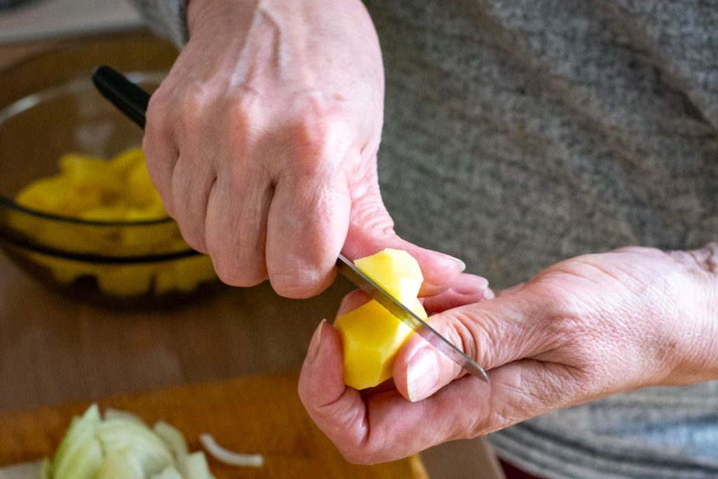 Cutting potatoes with a knife Lithuanian way that allows for uneven edges.