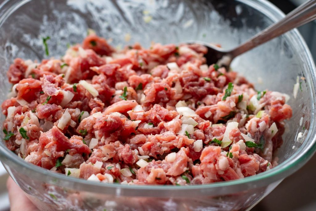 Lithuanian Meat Pie filling mixed in a glass bowl.