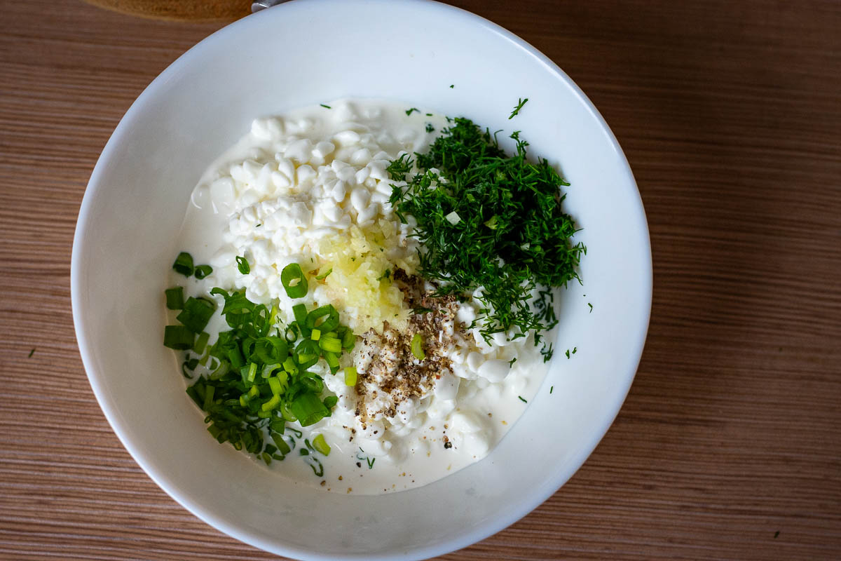 All ingredients for Lithuanain cottage cheese sauce in a white bowl.