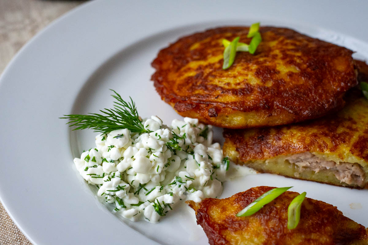 Lithuanain cottage cheese sauce served alongside meat stuffed potato pancakes.