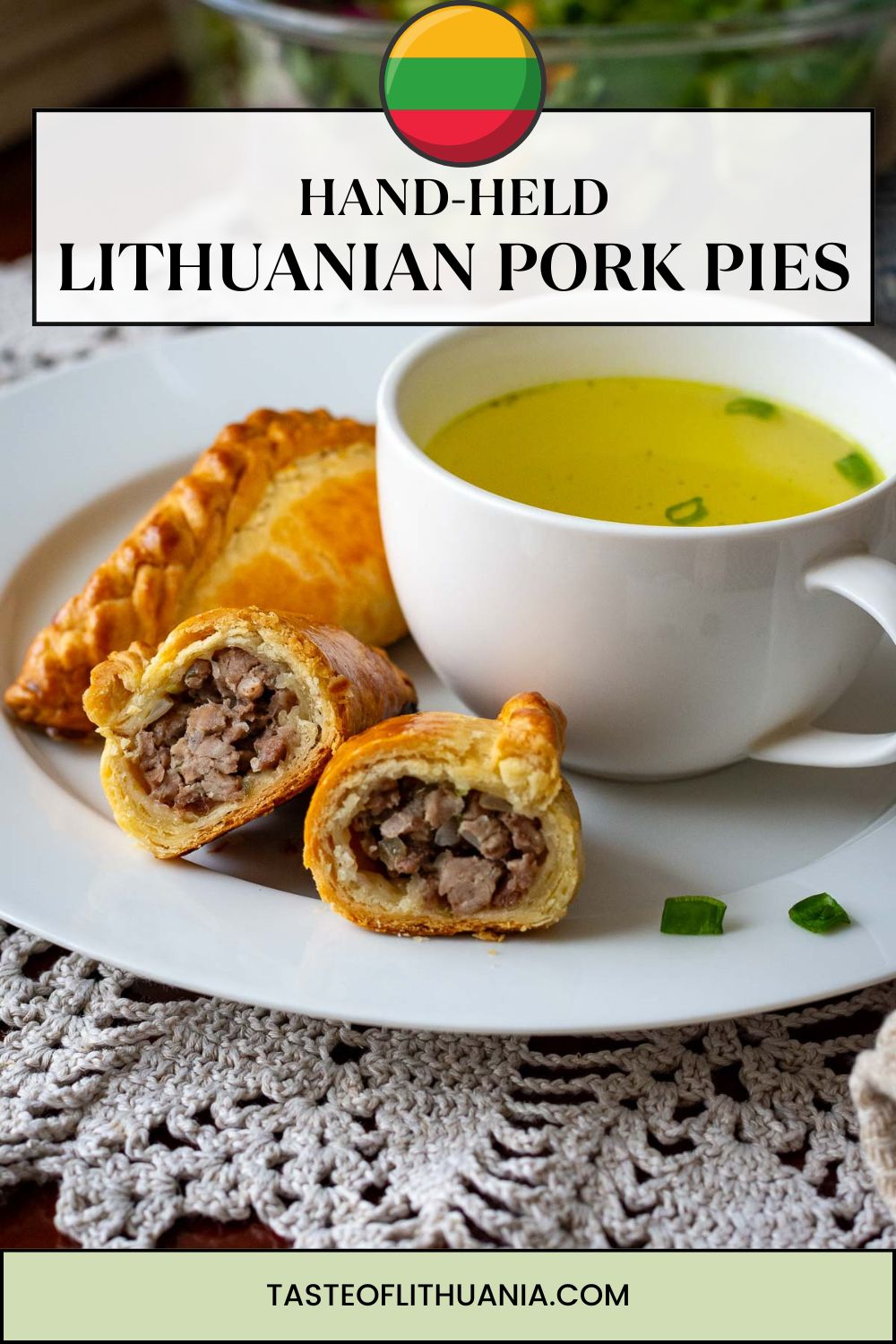 Lithuanian meat pies (known as kibinai) on a white plat with a bowlful of broth. Pin for Pinterest.