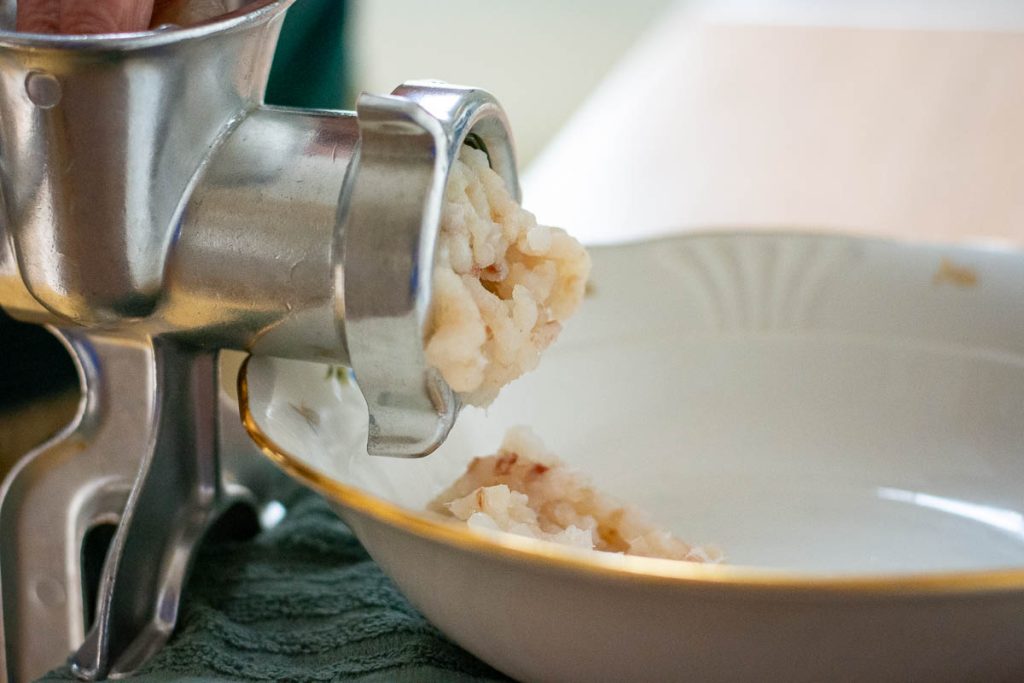 Pollock being minced in a meat mincer.