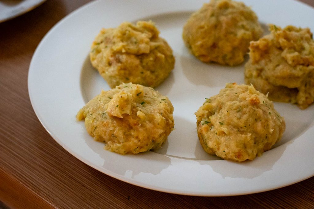 Fish mixture divided into balls on a white plate.