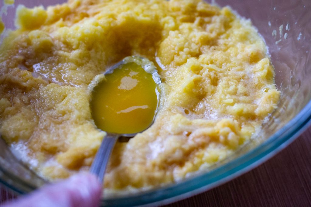 Spooning the liquid from the raw potatoes off.