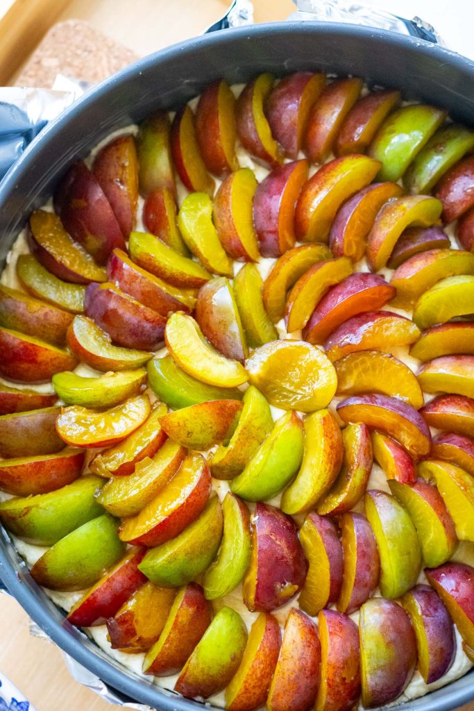 Plum quarters arranged in concentric circles on top of the cake batter.