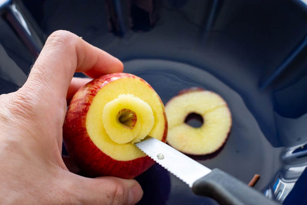 Cutting the core out of the apples.