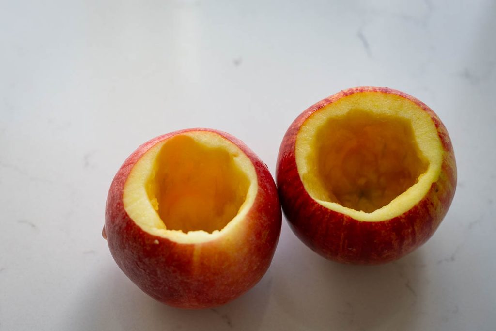 Hollowed apples on a light kitchen worktop.